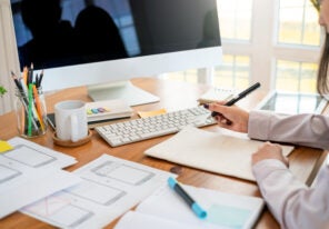 Designer woman drawing a website outline and website ux app development on mobile phone.