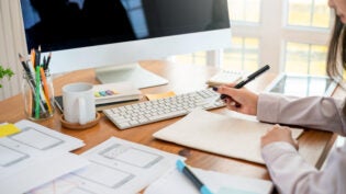 Designer woman drawing a website outline and website ux app development on mobile phone.