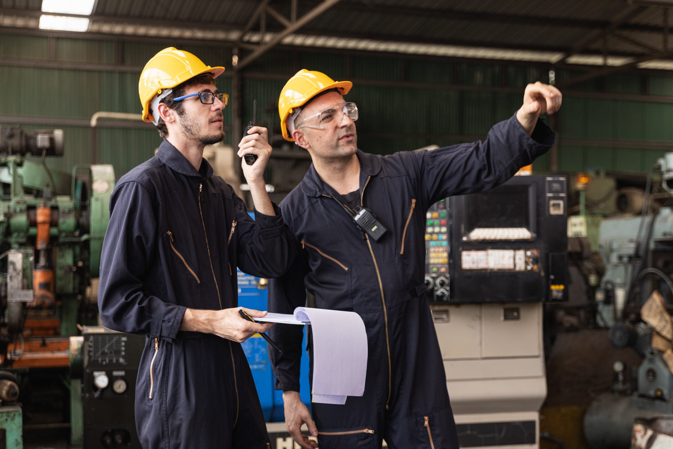 Group of industrial factory maintenance engineers inspect relay protection system using walkie talkie with copy space for your text. Industry, Maintenance, Engineering and construction concept.