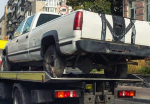 pickup vehicle accident transportation on flatbed tow truck machine on city street.