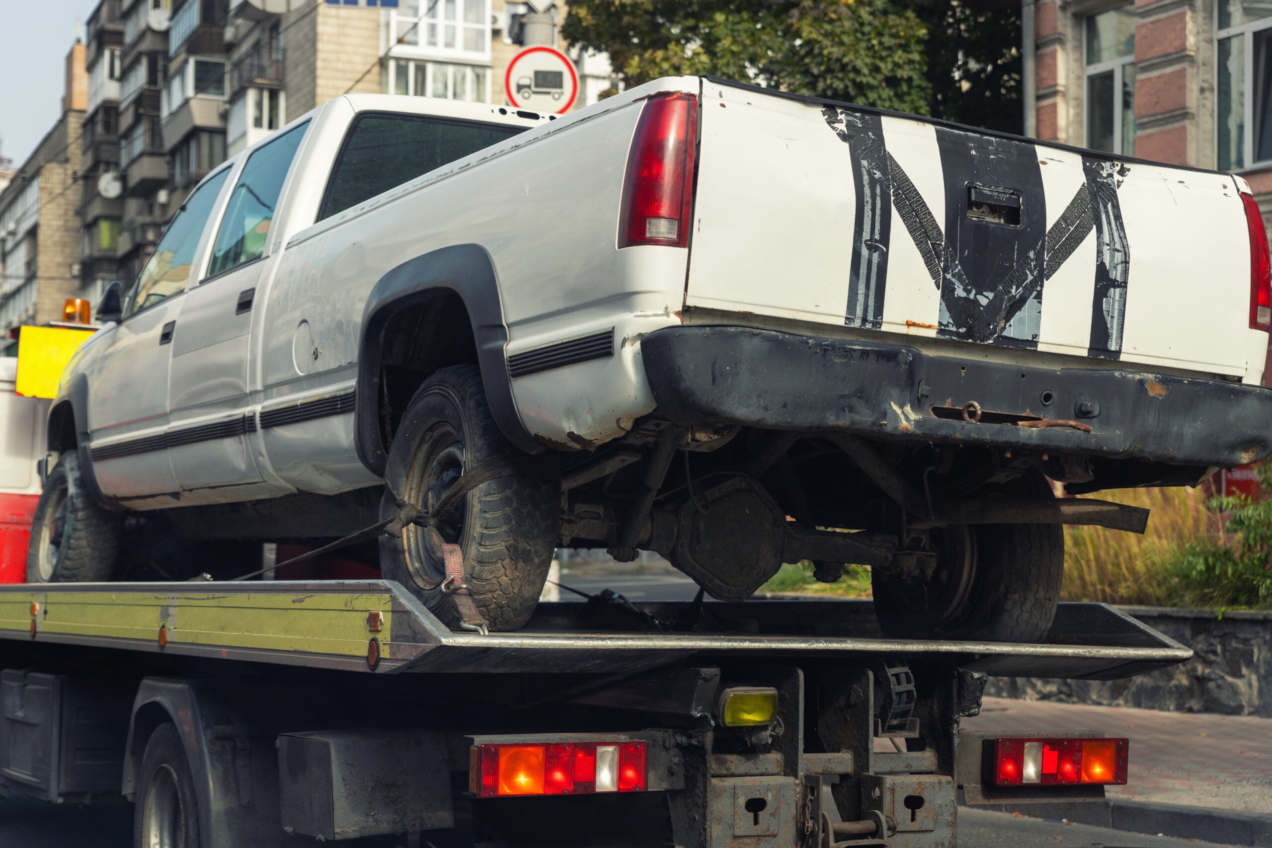 pickup vehicle accident transportation on flatbed tow truck machine on city street.