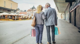 Senior couple carrying shopping bags and enjoying shopping