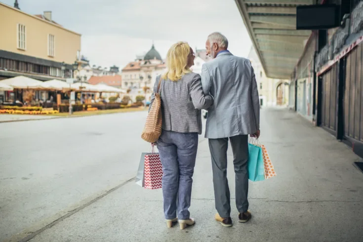 Senior couple carrying shopping bags and enjoying shopping