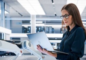 woman looking at open laptop in office setting