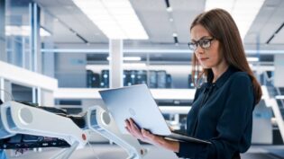 woman looking at open laptop in office setting