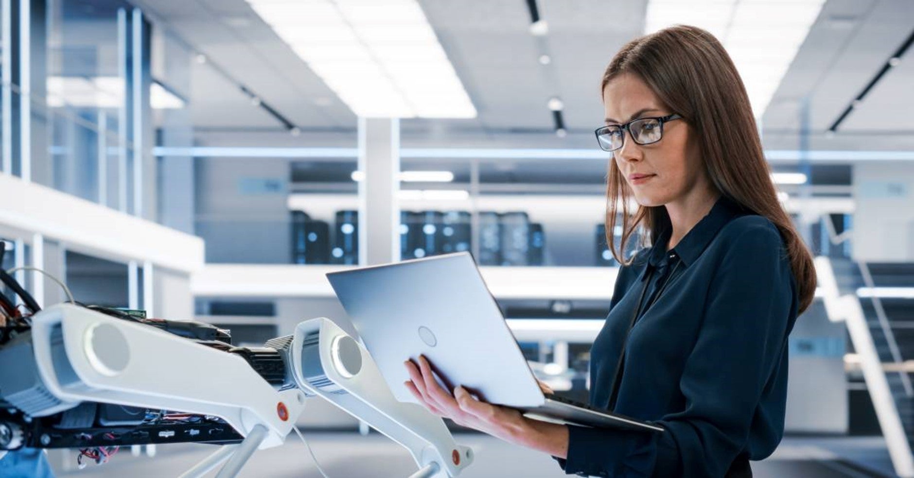 woman looking at open laptop in office setting