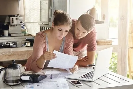 couple reading loan papers in kitchen