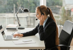 female secretary talking through headset in office