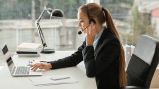 female secretary talking through headset in office