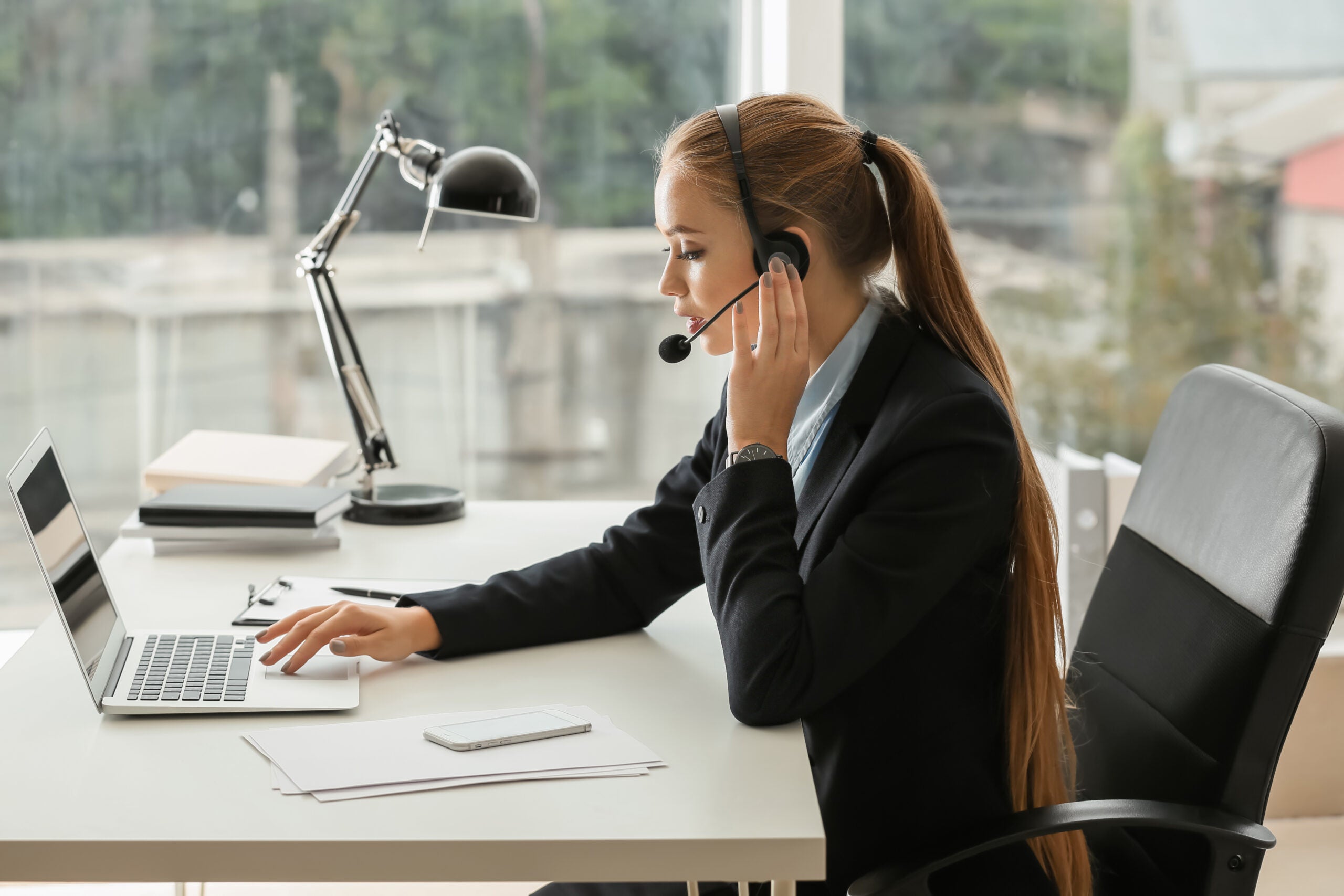 female secretary talking through headset in office