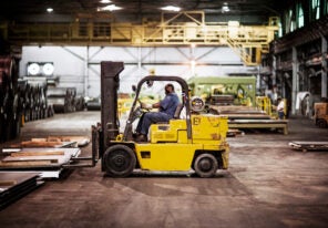 Man driving forklift in warehouse