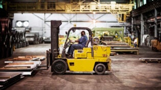 Man driving forklift in warehouse