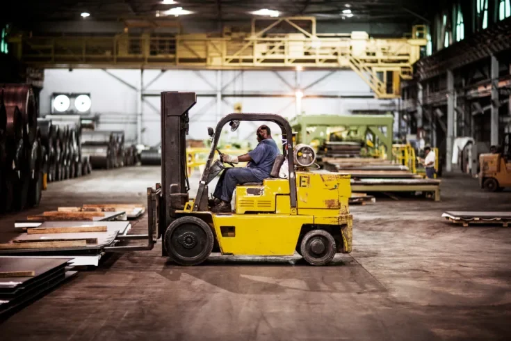 Man driving forklift in warehouse