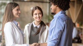 Business people shaking hands at office showing trust.