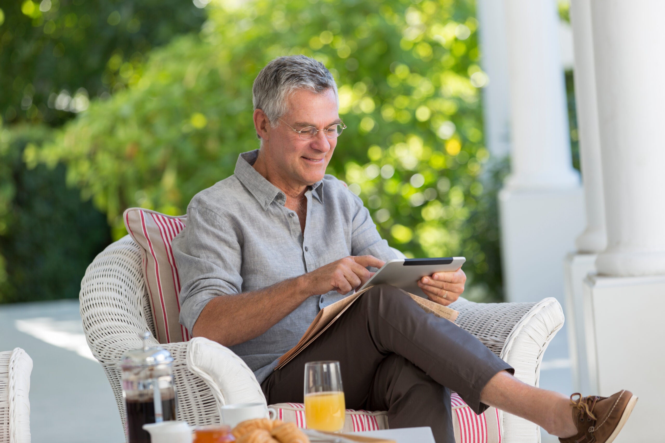 Senior man using digital tablet on patio