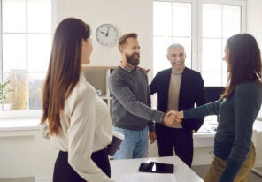 Happy, smiling business people meeting, making an acquaintance and shaking hands