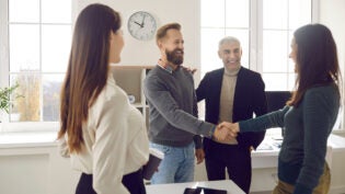 Happy, smiling business people meeting, making an acquaintance and shaking hands