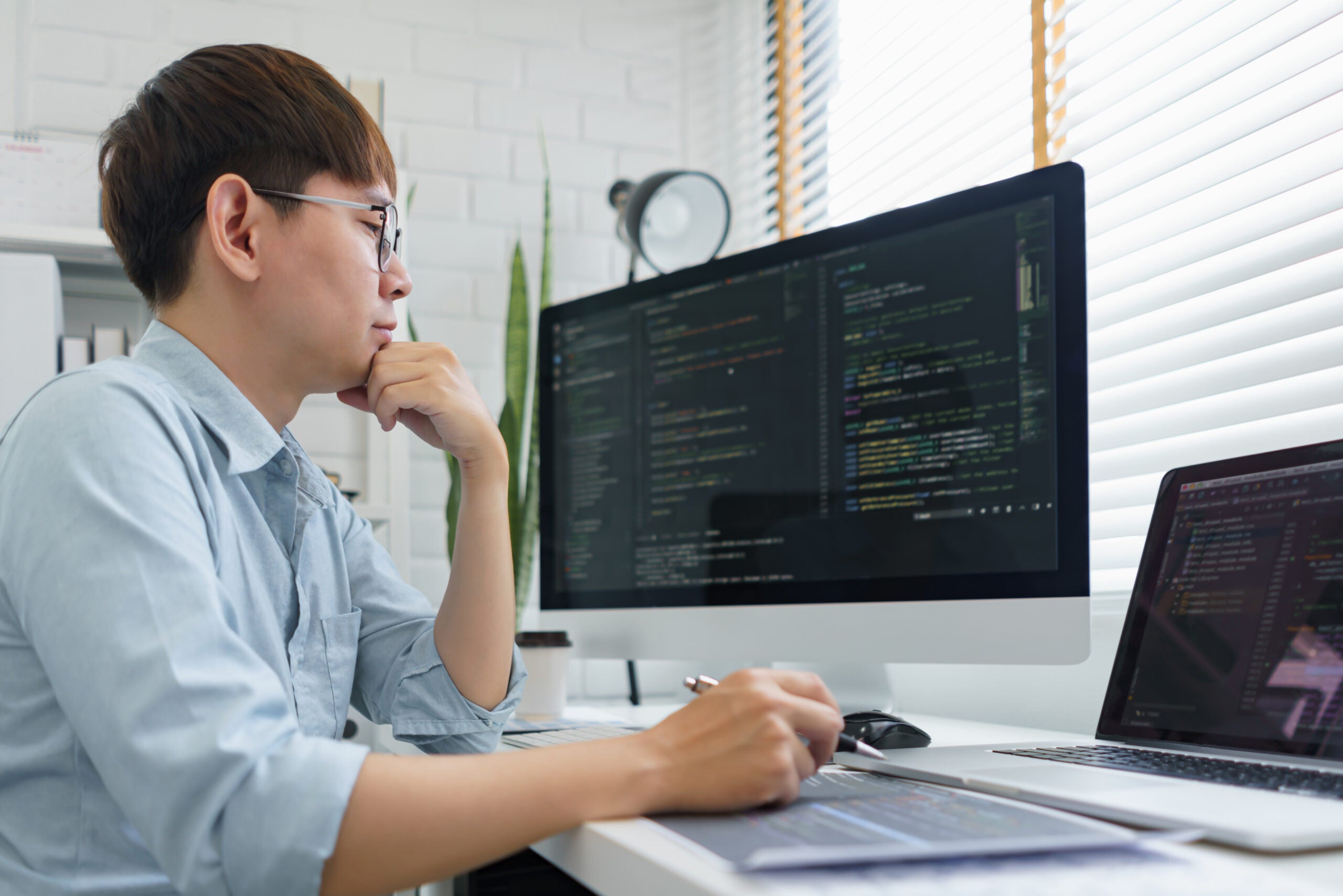 Male programmer read data code to thinking about developing website.