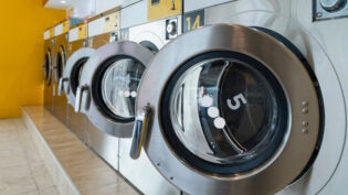 A row of qualified coin-operated washing machines in a public store.