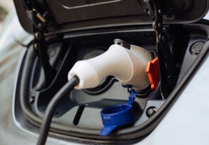 White electrical nozzle being plugged into e-car