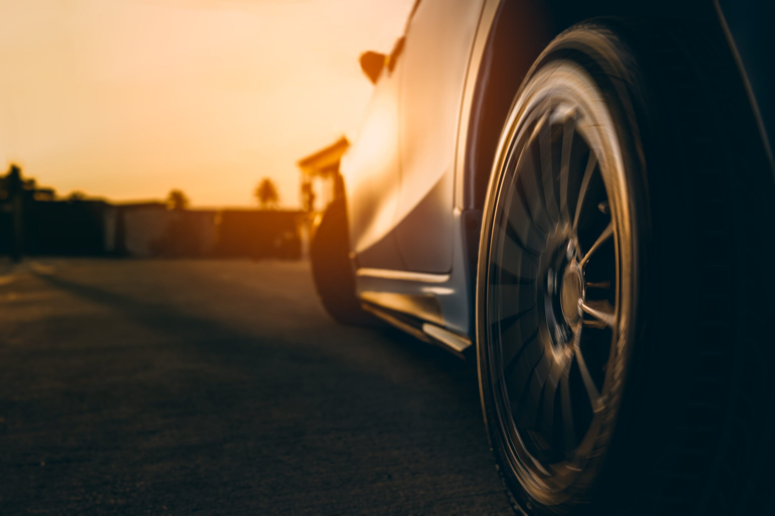 Closeup spinning alloy sports wheel car driving on the road fast