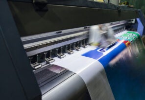 Large format inkjet printer working on vinyl paper in workplace