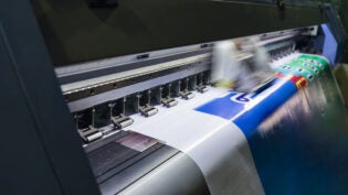 Large format inkjet printer working on vinyl paper in workplace