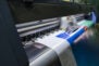 Large format inkjet printer working on vinyl paper in workplace