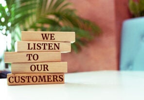 Wooden blocks with words 'We listen to our customers'. Business concept