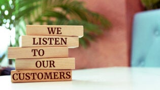 Wooden blocks with words 'We listen to our customers'. Business concept