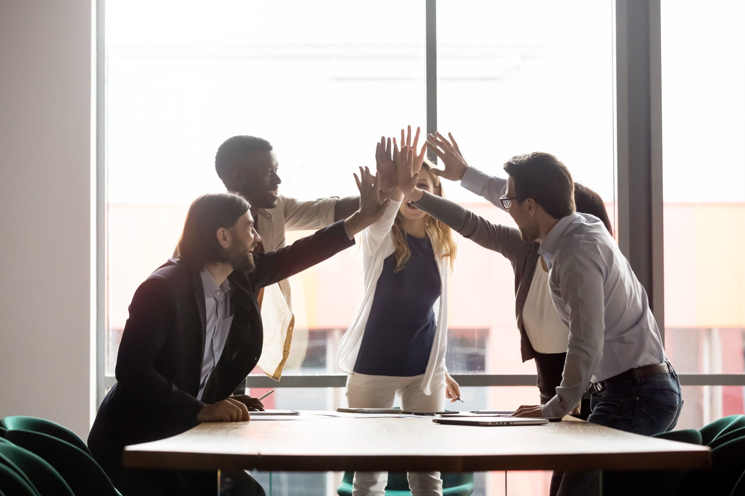 diverse group of businesspeople workmates celebrating common success gathered in board room