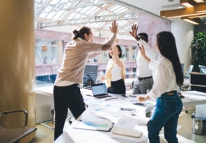 team of employees satisfied with productive teamwork and brainstorming sessions during business development process, happy male and female crew giving high five for achievement