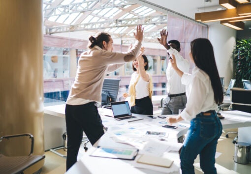 team of employees satisfied with productive teamwork and brainstorming sessions during business development process, happy male and female crew giving high five for achievement