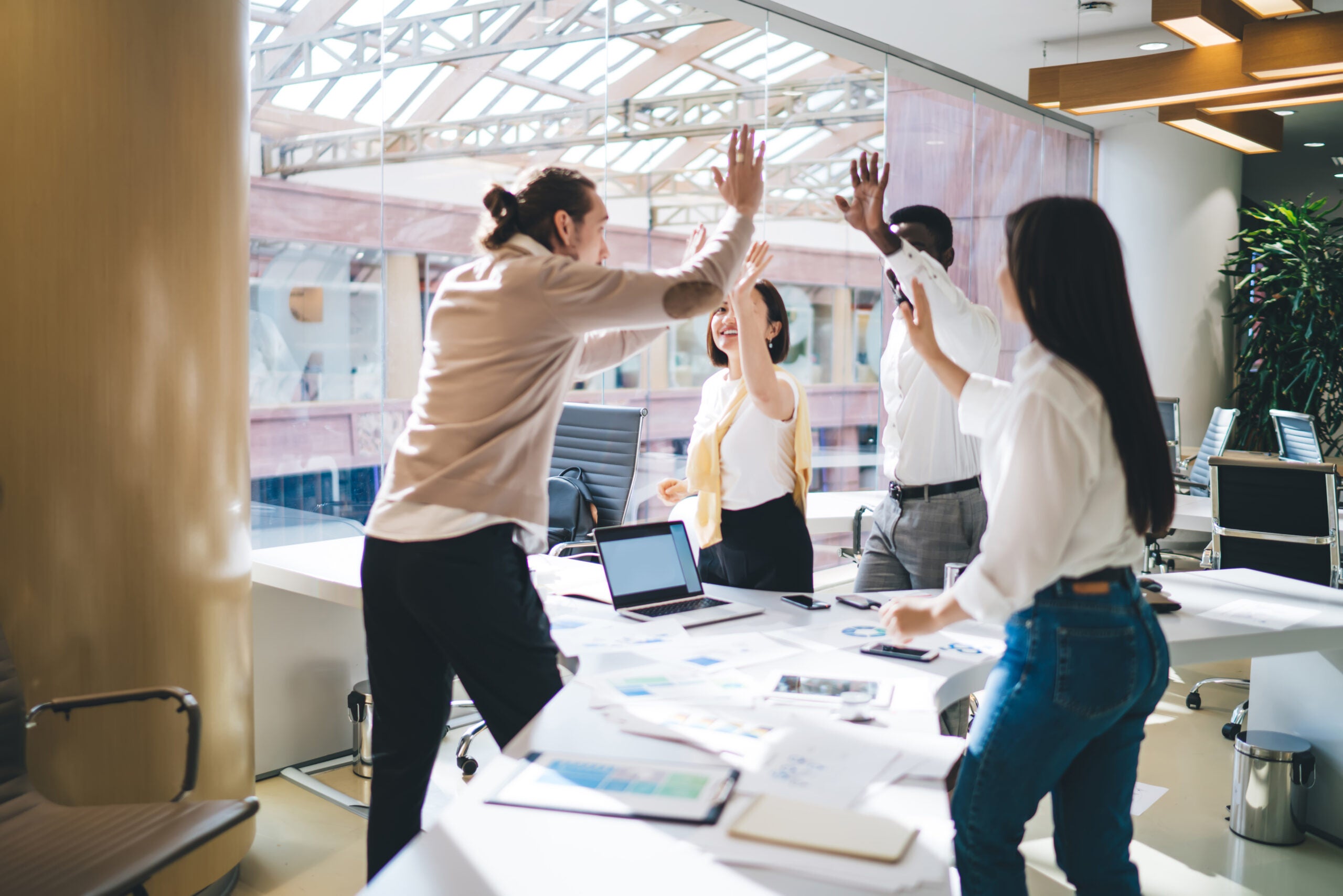 team of employees satisfied with productive teamwork and brainstorming sessions during business development process, happy male and female crew giving high five for achievement