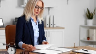 Mature female judge working with documents at table