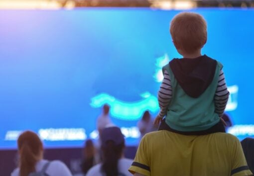 Back view of child on father's shoulders