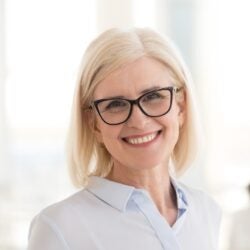 professional caucasian blond woman with glasses in white shirt