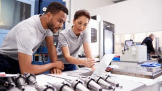 Two Engineers Using CAD Programming Software On Laptop