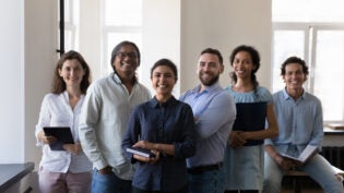 diverse office employees pose at workplace