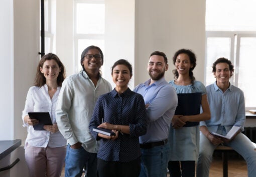 diverse office employees pose at workplace