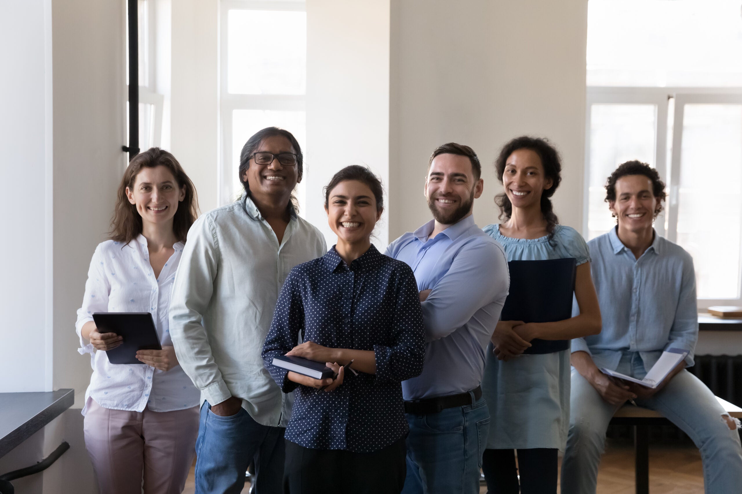 Group of happy diverse office employees pose at workplace diverse office employees pose at workplace