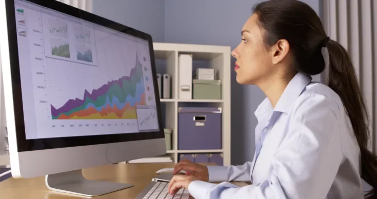 Businesswoman analyzing data on a monitor