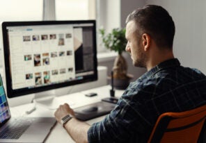 man working remotely on a computer from home office