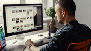man working remotely on a computer from home office