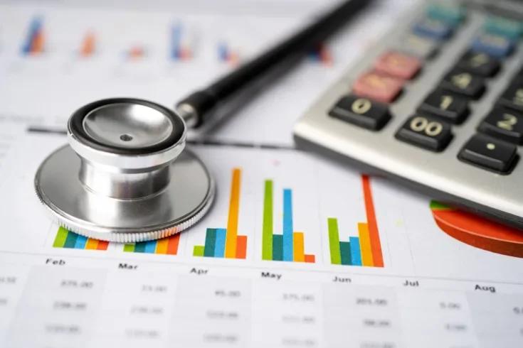 Stethoscope and US dollar banknotes on chart or graph paper,