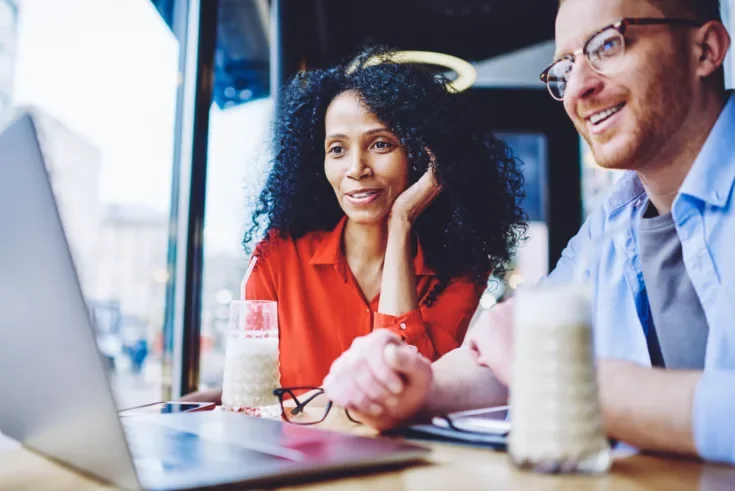Happy diverse male and female friends watching motivation webina