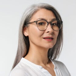 adult mature woman with long gray hair wearing eyeglasses and office clothes