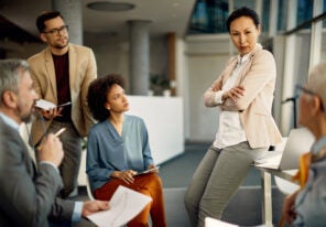 Confident CEO communicating with her business team during a briefing in the office.
