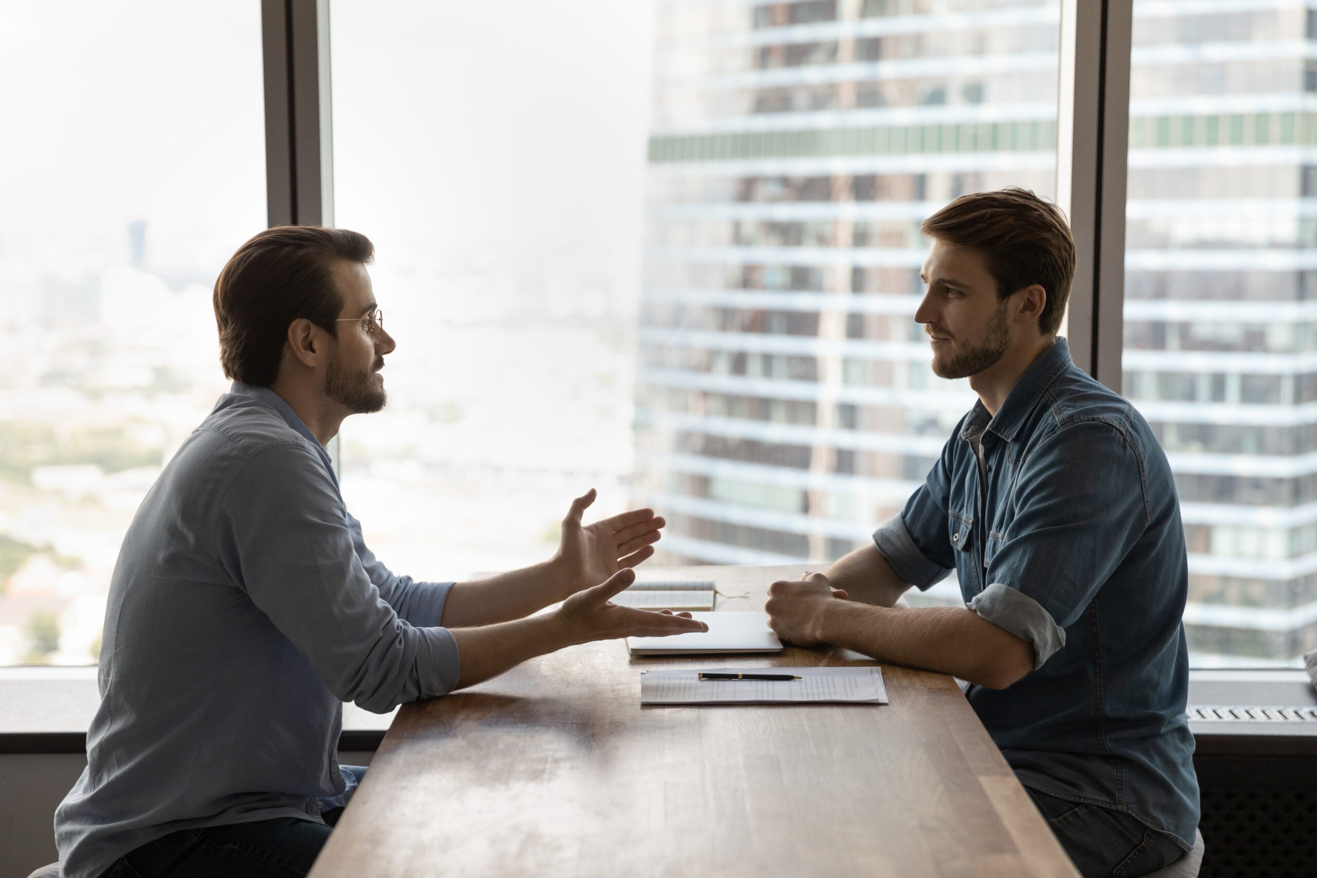 Confident young male job seeker talking with skilled hr manager. Confident young male job seeker talking with skilled hr manager.