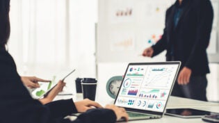 Businesswoman in business meeting using laptop computer proficiently at office for marketing data analysis . Corporate business team collaboration concept .